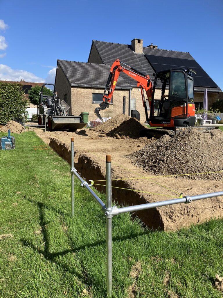 Minigraver bij de grondwerken voor de fundering van de tuinberging in Diepenbeek