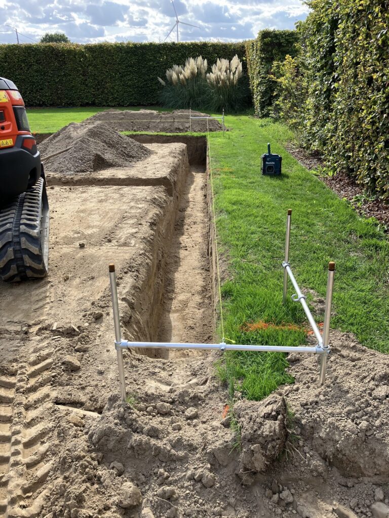 Uitgegraven vorstrand langs de haag voor de tuinberging met overdekt terras in Diepenbeek