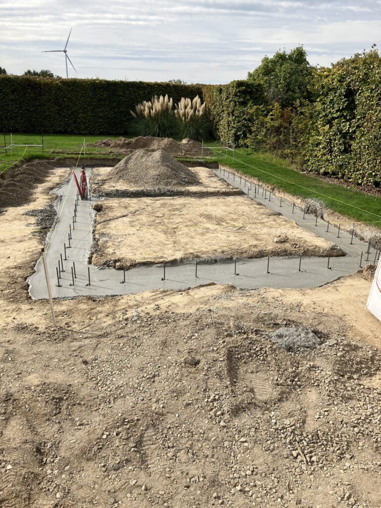 Gestorte vorstranden met wapening rond de fundering van de tuinberging in Diepenbeek